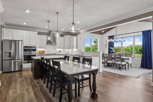 The upgraded Chef's Kitchen features custom cabinetry including the island and dining table.
