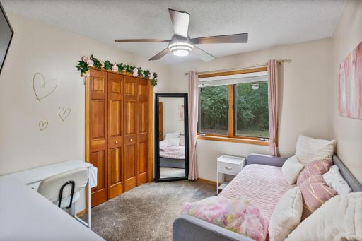 Main-level bedroom with generous closet space and peaceful wooded views.