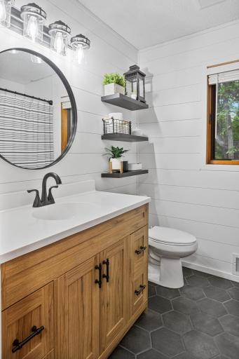 Thoughtful finishes and floating shelves add style and practical storage to the updated bath.