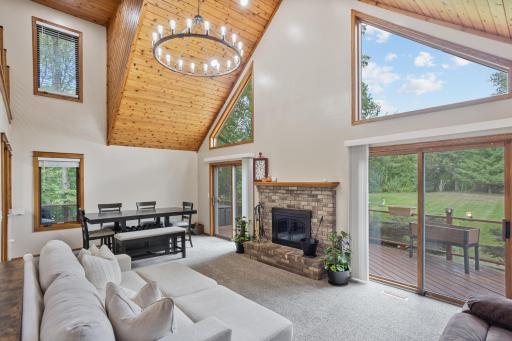 The dramatic great room is the heart of the home, featuring soaring vaulted wood ceilings, expansive windows and a cozy brick fireplace.