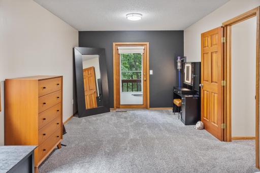 Private access to a small balcony brings the wooded setting right outside the primary bedroom.