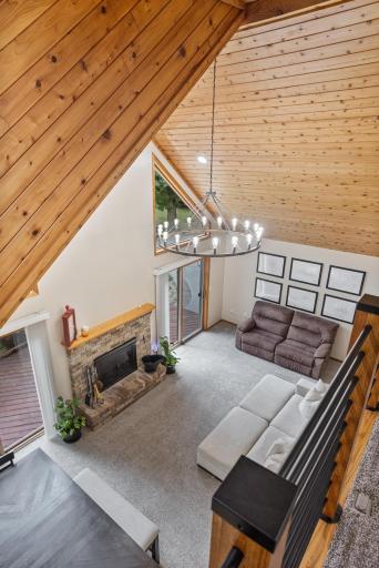 From the loft, take in the soaring wood ceiling, statement chandelier, fireplace and walls of windows that make this home truly special.