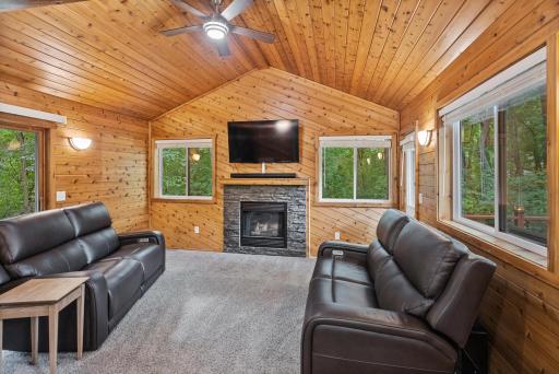 This cozy wood-clad family room feels like your own private cabin retreat, complete with a second fireplace and views of the surrounding trees.
