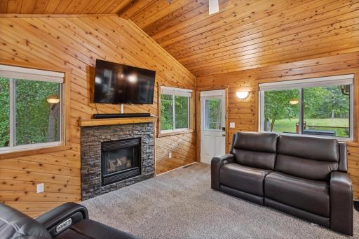 Gather around the second fireplace while windows on three sides bring the peaceful wooded setting indoors.