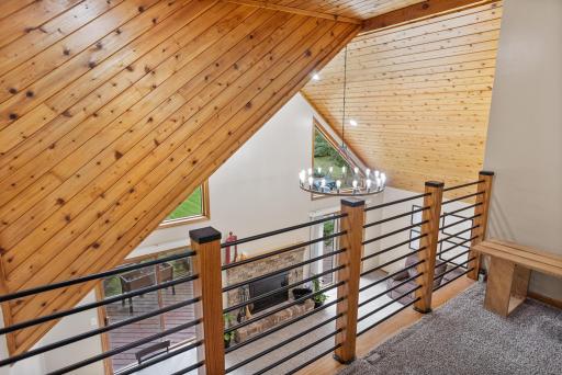The loft showcases the home’s beautiful woodwork and dramatic vaulted architecture from above.