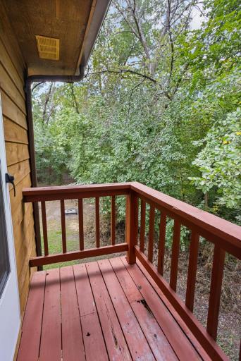 Step outside to a quiet balcony surrounded by mature trees and peaceful wooded views.