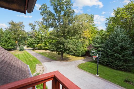 A peaceful perch overlooking the expansive yard, mature trees and winding driveway.