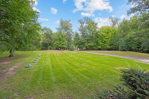 A wide-open stretch of lawn framed by mature trees offers space to play, garden or simply enjoy the view.