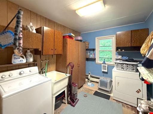 Main-level laundry room offers plenty of storage, a utility sink, window and room to keep everyday household tasks organized.