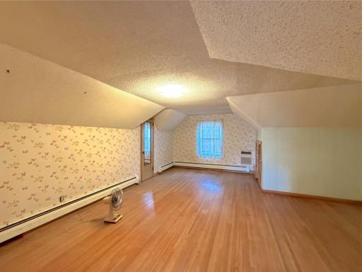 The third bedroom offers a generous layout with charming sloped ceilings, hardwood floors and great built-in storage.