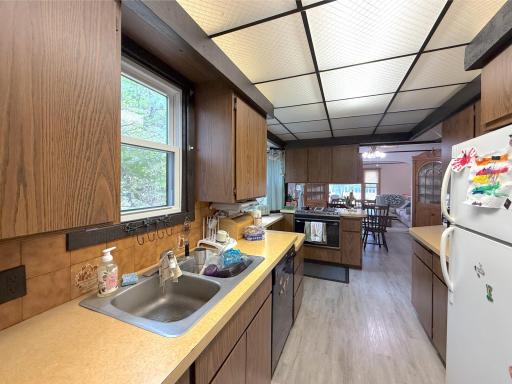 A functional kitchen layout provides ample workspace and storage, with large windows bringing in views of the surrounding greenery.