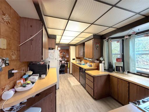 Spacious galley-style kitchen offers plenty of cabinet and counter space, along with updated flooring and great natural light.