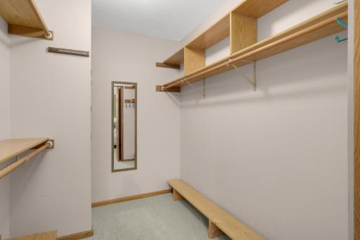 Large walk-in closet with built-in shelving, hanging space and room for additional storage.