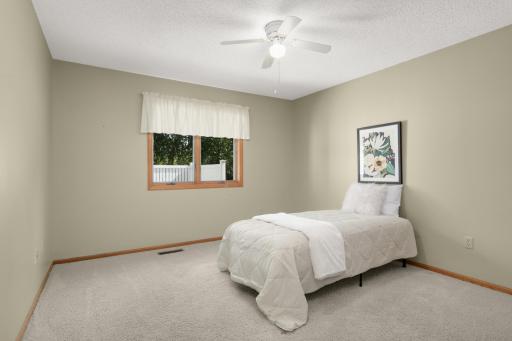 Nicely sized second Bedroom with ceiling fan and views toward the mature trees.