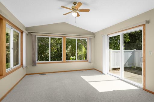 Vaulted Sunroom surrounded by windows with views of the mature trees behind the home.