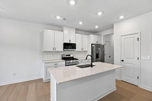 This chef-ready kitchen is designed to accommodate modern living, with a multiuse center island to add food prep and seating space, gleaming quartz countertops and abundant cabinetry room.