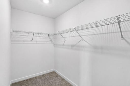 A large walk-in closet with mesh-wire shelving provides abundant room to store wardrobes, shoes, accessories and much more