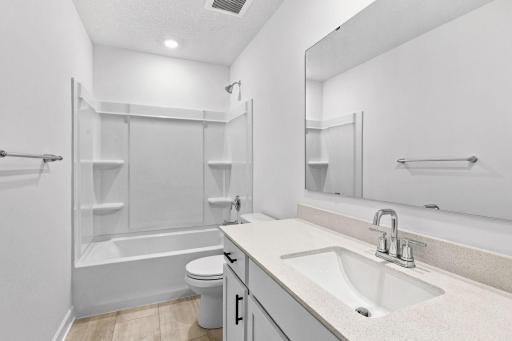 A full-sized bathroom on the second floor comes well-equipped with a generously sized quartz-topped vanity and a combination shower and tub to maximize the interior space.