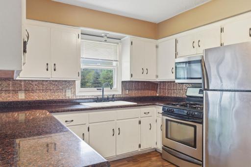 Kitchen featuring stainless-steel appliances, backsplash and laminated countertop