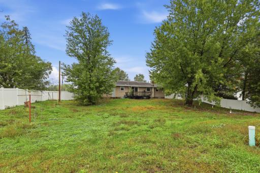 A large backyard surrounded by mature trees, ready for your vision and outdoor enjoyment.