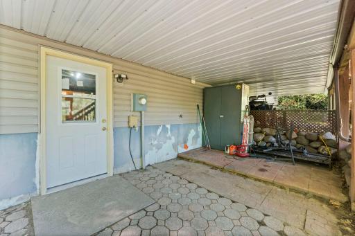 View of under deck storage area, patio and entrance to the lower level