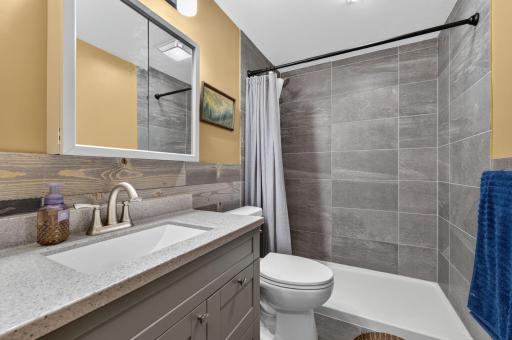 Renovated main bathroom has tiled walk-in shower