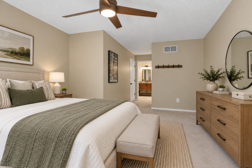 Spacious primary bedroom with direct walk-through access to the full bathroom. Digitally Staged