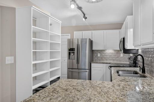 Custom California Closets shelving provides thoughtfully designed kitchen storage.