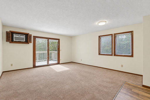 Unstaged large living room. Entrance to deck.