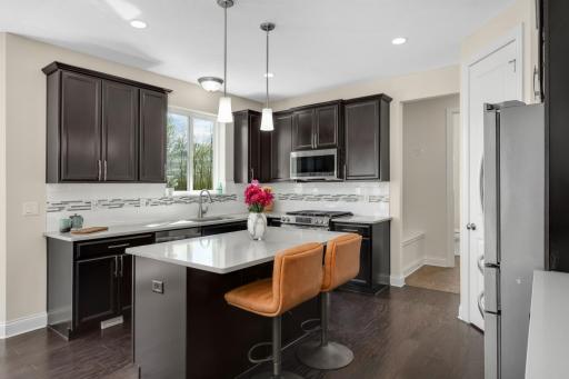 Spacious kitchen with oversized island seating, stainless steel appliances, and abundant cabinetry.