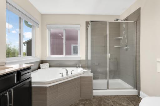 Private primary bath with large soaking tub, separate walk-in shower, and functional layout.
