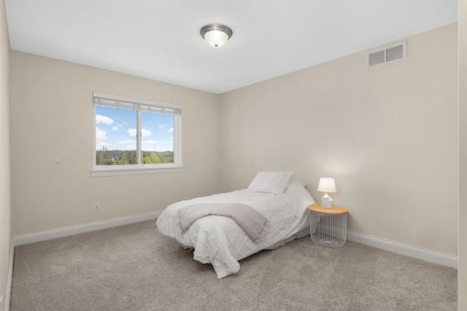 Bright upper-level bedroom with large window and versatile layout.