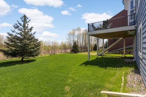 Spacious backyard with deck above, overlooking peaceful nature and private views.