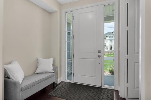 Welcoming front entry with natural light, sidelights, and functional drop zone with bench.