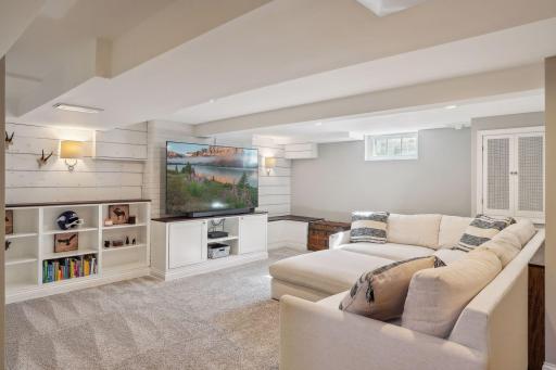 Gorgeous basement design with paneled walls, newer carpet (2020) and built-ins.