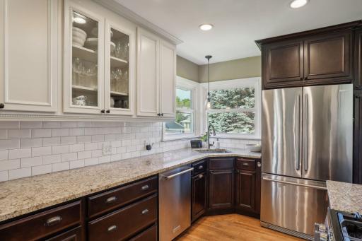 Granite countertops, stainless-steel appliances, subway tiled backsplash, and updated cabinetry. Corner window brings a ton of natural light into this kitchen space.