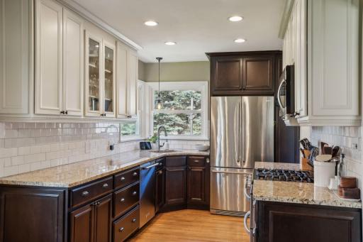 The beautifully remodeled kitchen is the heart of the home, featuring granite countertops, stainless-steel appliances, updated cabinetry, and an informal dining nook.