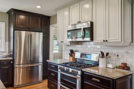 The beautifully remodeled kitchen is the heart of the home, featuring granite countertops, stainless-steel appliances, updated cabinetry, and tiled backsplash.
