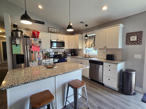 Kitchen w/Granite Countertops, Tile Backsplash, White Cabinets and Center Island