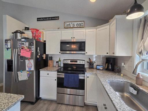 Kitchen w/Granite Countertops, Tile Backsplash, White Cabinets and Center Island