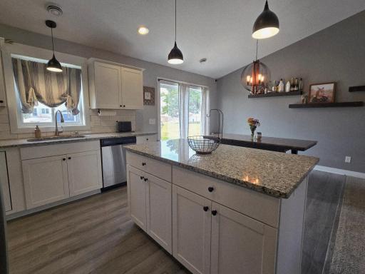 Kitchen w/Granite Countertops, Tile Backsplash, White Cabinets and Center Island