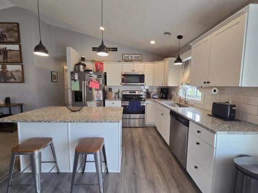 Kitchen w/Granite Countertops, Tile Backsplash, White Cabinets and Center Island