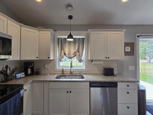 Kitchen w/Granite Countertops, Tile Backsplash, White Cabinets and Center Island