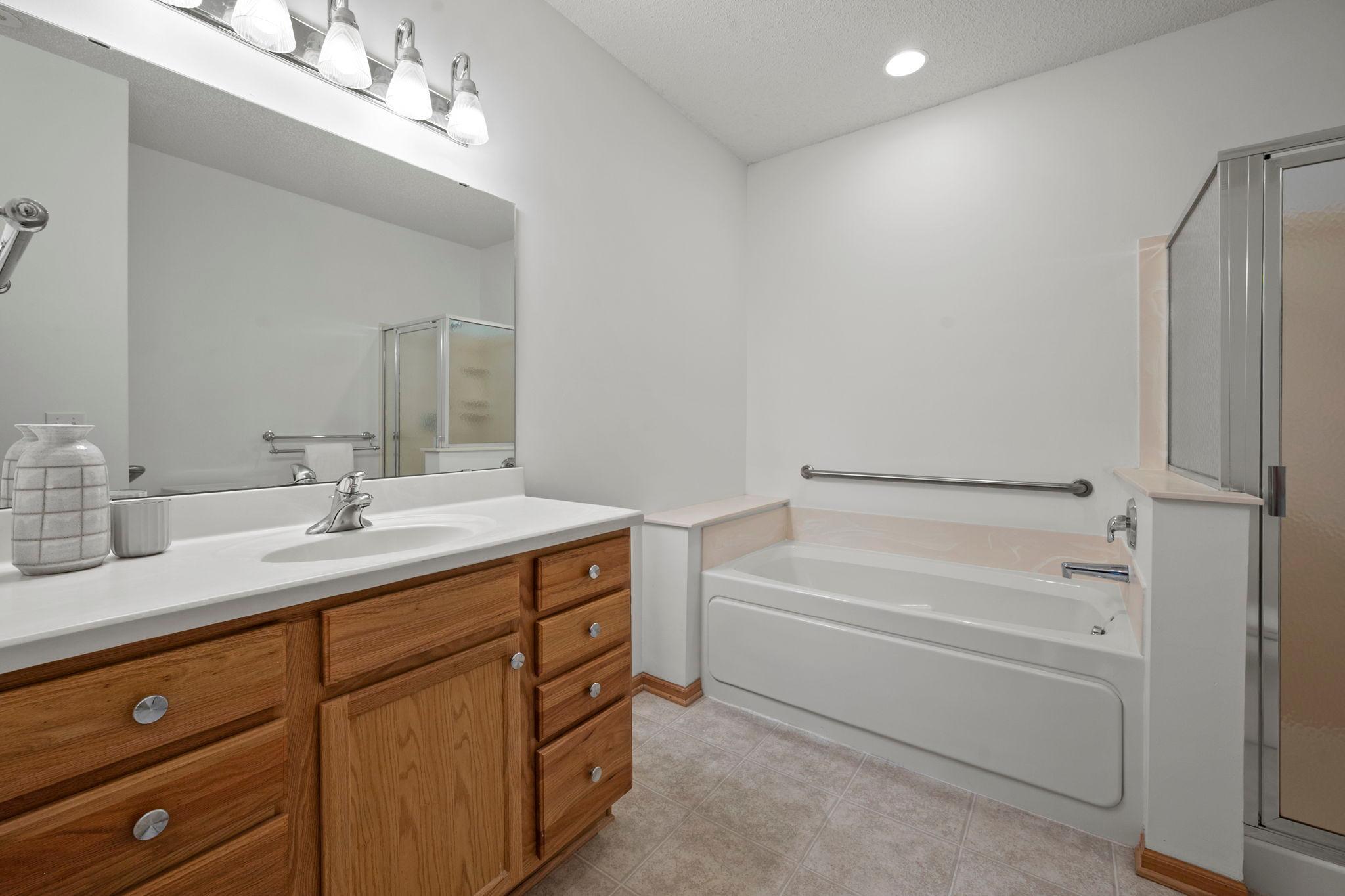 The primary suite private bath includes a jetted tub and a separate walk-in shower.
