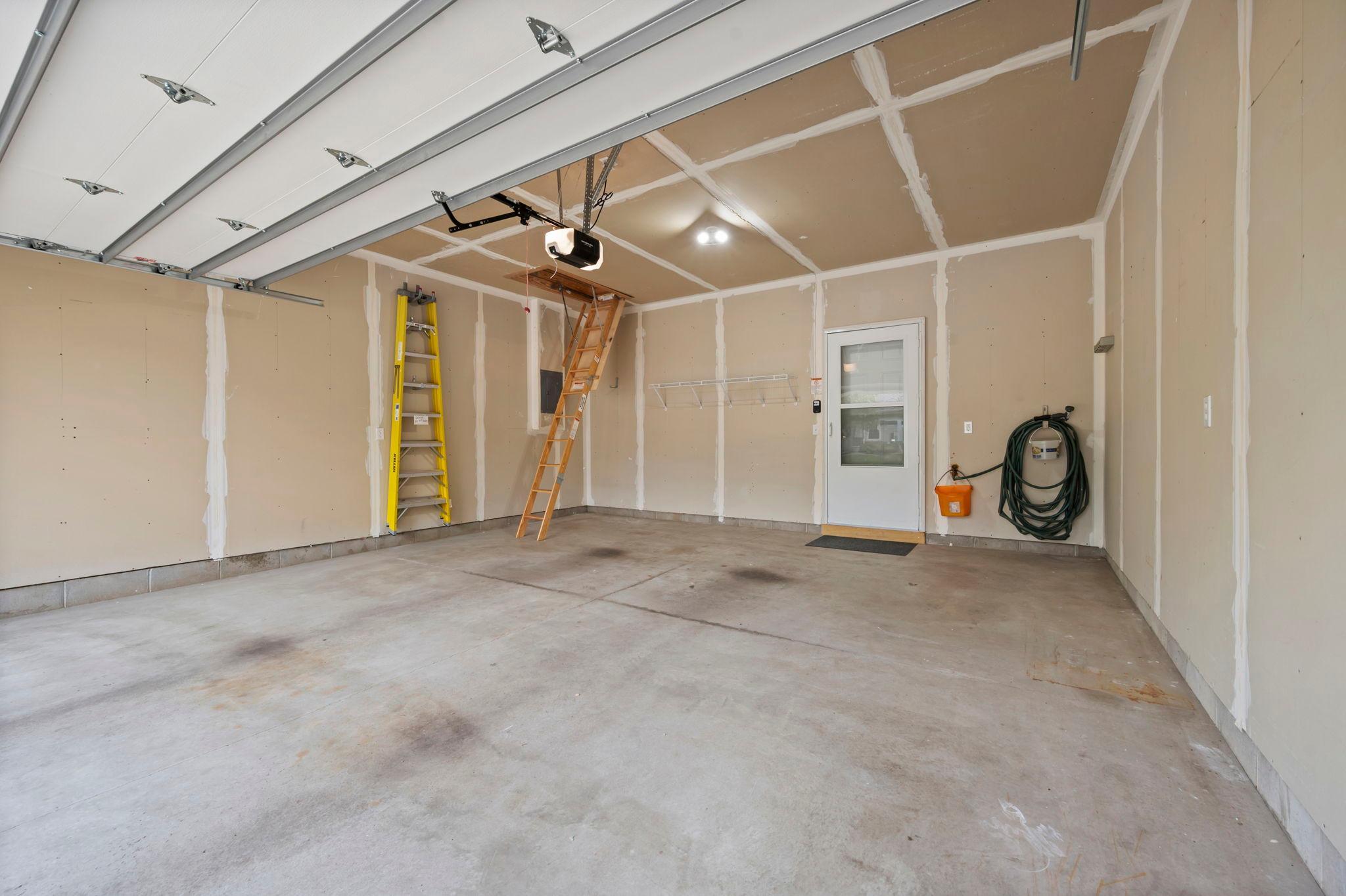 The spacious garage offers plenty of room for parking and storage, with pull-down stairs to the attic storage area. The garage door and opener have both been updated.
