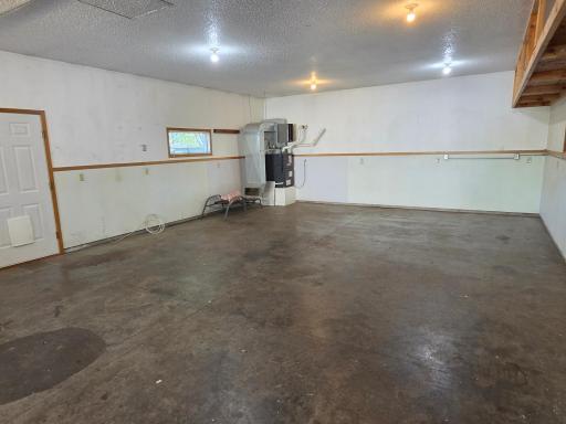 View of the back half of garage. Even has its own furnace to keep it warm for your shop, recreation space, or as some other owners had, a sauna!
