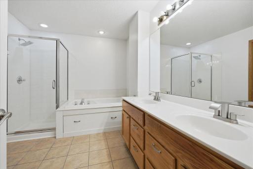 Spa-like full bathroom complete with dual sinks, oversized soaking tub, separate walk-in shower, and direct access from the primary suite.