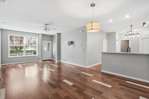 Bright and welcoming entryway featuring soaring 9' ceilings, updated wood flooring, and large windows that fill the space with natural light.