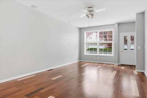 Spacious living room with an open layout, expansive windows, and beautiful updated wood flooring perfect for everyday living or entertaining guests.