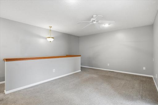 Bright and open loft area with plush newer carpet, neutral dÃ©cor, and plenty of room for additional living or entertaining space.